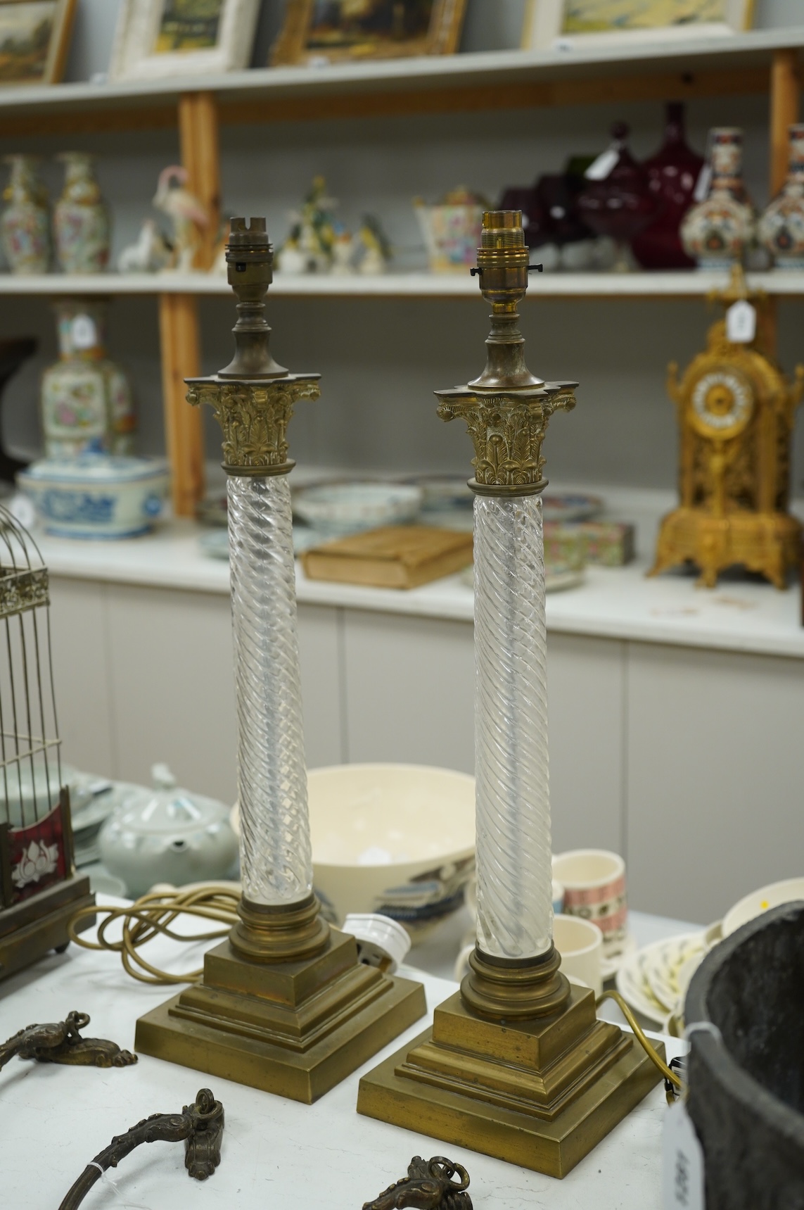 A pair of brass and glass Corinthian column lamps, 59cm high overall